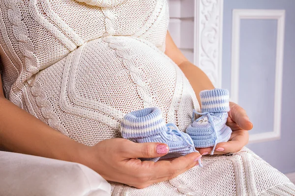 임신부 뱃속에 있는 태어나지 않은 아기를 위한 작은 신발 — 스톡 사진