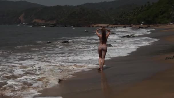 Mujer caminando por la playa con olas . — Vídeos de Stock