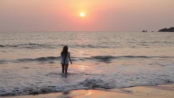 Mujer joven saltando en la playa al atardecer . — Vídeos de Stock