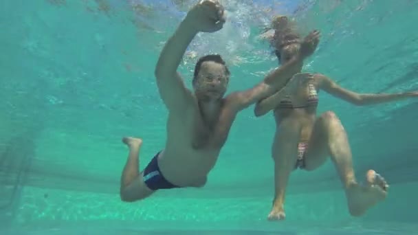 Man and woman dive underwater. Shot from underwater. — Stock Video