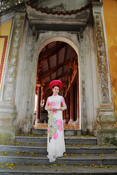 Vietnamlı bir tapınak önünde Ao Dai kostüm giyen kadın
