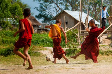 Futbol oynayan kırmızı elbise içinde üç rahipler