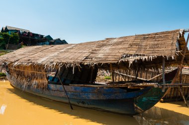Çamurlu nehir üzerinde ahşap tekne