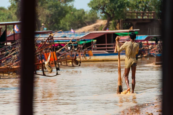 Man covered in mud with fishing net — Stock Photo, Image