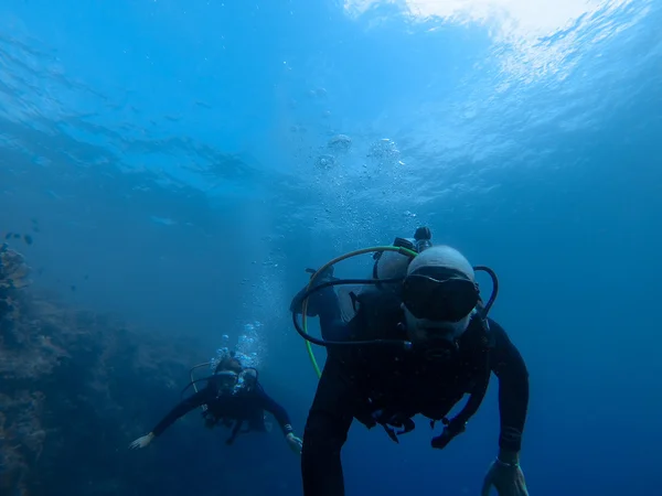 Homem e mulher mergulhando no mar azul profundo — Fotografia de Stock