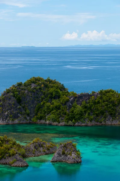 Pequeñas islas verdes pertenecientes a la isla Fam en el mar de Raja Ampat, Papúa Nueva Guinea — Foto de Stock