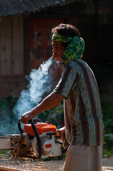 Ásia homem com bandana fumar e usando seu motosserra — Fotografia de Stock