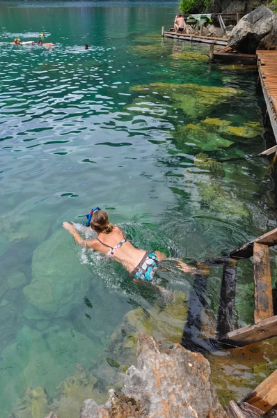 Mulher nadando em lago lagoa muito limpo e claro Água ao lado de um caminho de madeira — Fotografia de Stock