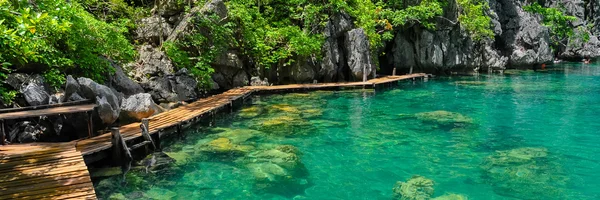 Sehr sauberes und klares Wasser des Lagunensees neben einem Holzweg — Stockfoto