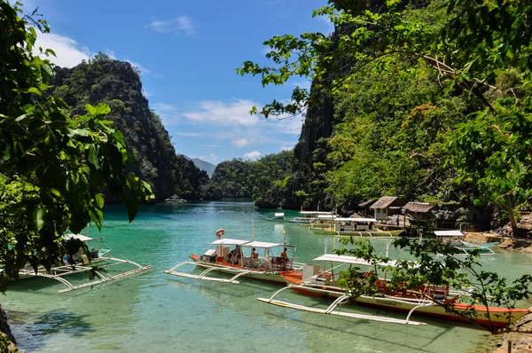 Barcos filipinos tradicionales de madera en una laguna azul en la isla tropical —  Fotos de Stock