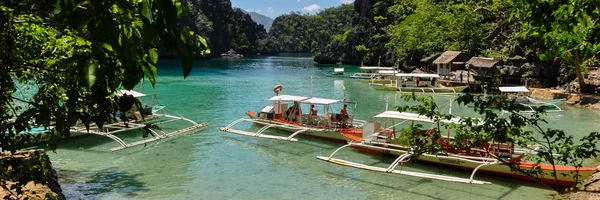 Tropik ada, mavi bir lagün geleneksel ahşap filipino tekneler — Stok fotoğraf