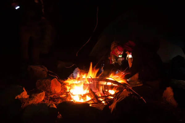 Wanderer versammelten sich nachts um ein Lagerfeuer mit Langzeitbelichtung — Stockfoto