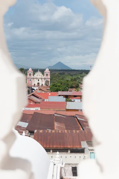 Κινηματογράφηση σε πρώτο πλάνο από λευκό πέτρινο κιγκλίδωμα, κοιτάζοντας μέσα από πάνω από το αστικό τοπίο ΕΓ Leon με ένα μεγάλο καθεδρικό ναό ροζ — Φωτογραφία Αρχείου