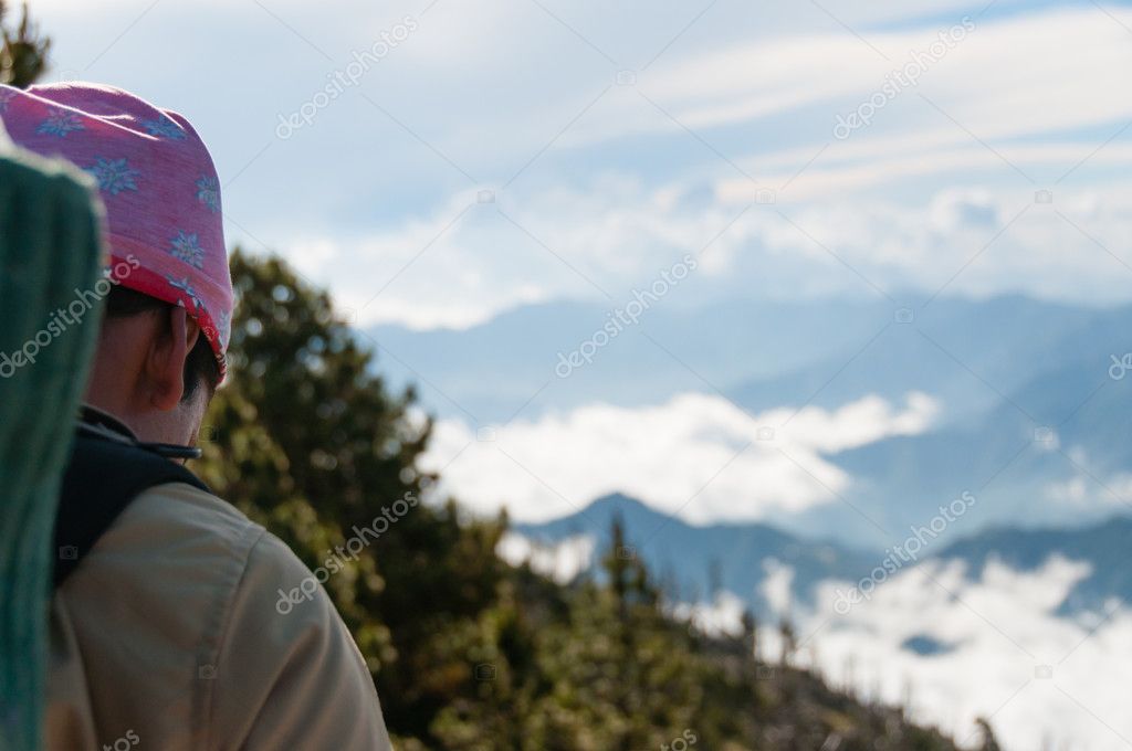 Young man with bandana from the side walking towards cloudscape and mountain Tajamulco