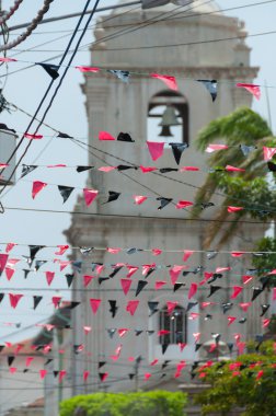Kırmızı ve siyah plastik Triangled asılı bir büyük beyaz kilise önünde satırlarındaki