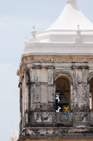 Homem vestindo camisa amarela Sentado na borda do topo de uma igreja com telhado branco — Fotografia de Stock