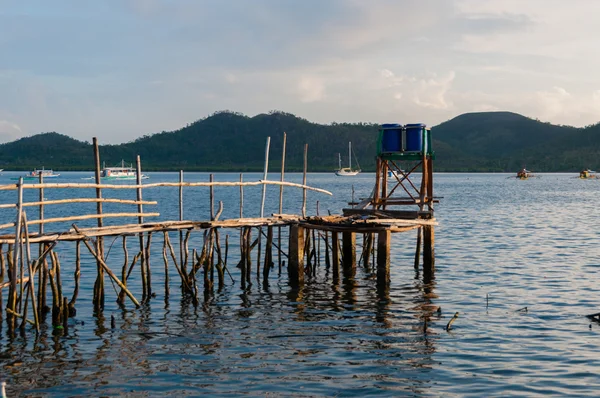 Small wood jetty in front of ocean and island — Stock Photo, Image