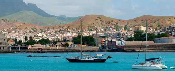 Barcos em frente a pequena cidade na costa azul do oceano com fundo de montanha, Cabo Verde — Fotografia de Stock