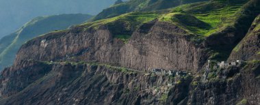 Bulut siyah kaya taş sahil evleri ve cape verde Adası yeşil tepe ile