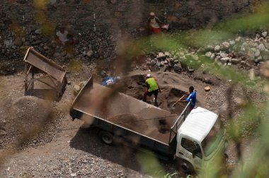 Kamyon ve inşaat alanında çalışan adam şube bakın