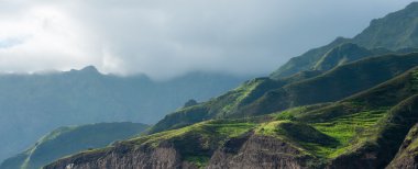 Bulut siyah kaya taş sahil evleri ve cape verde Adası yakın Afrika yeşil tepe ile