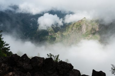 Dağların tepesinden derin vadiye, bulutların arasından Cape Verde adasına bak.