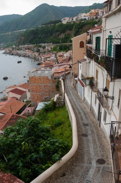 Smalle straat en trappen naast leuke Italiaanse huizen in oude stad van Scilla tegenover de Oceaan — Stockfoto