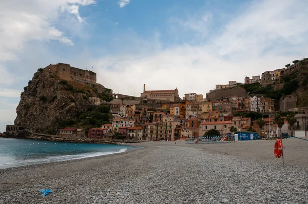 Praia de pedra e velha pequena cidade italiana em penhasco sob o céu azul — Fotografia de Stock