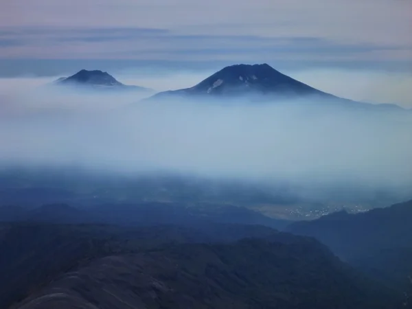 Ηφαίστεια lonquimay και toulhuaca στη Χιλή πάνω από μια ομίχλη — Φωτογραφία Αρχείου