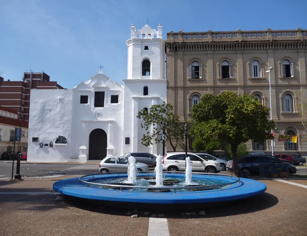 Fontana rotonda blu di fronte ad una chiesa bianca — Foto Stock