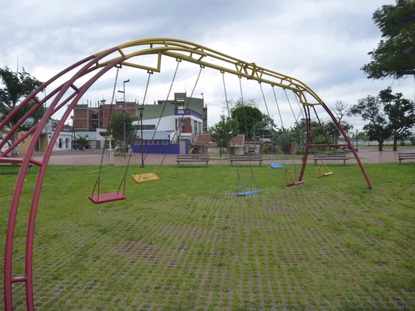 Columpios coloridos vacíos en el patio de los niños —  Fotos de Stock