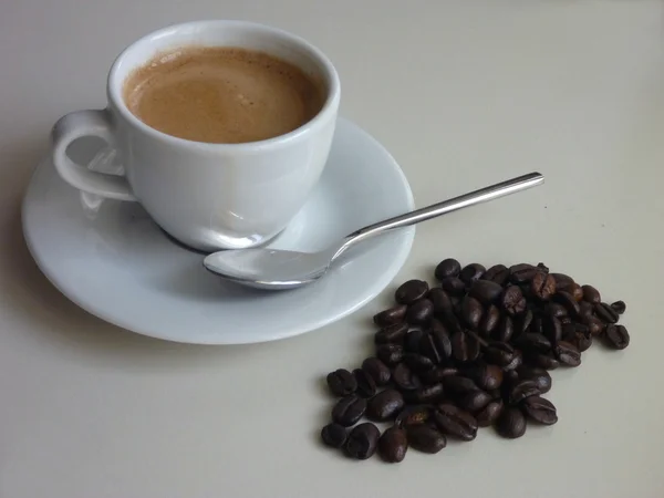 Чашка свіжої смачної кави з кавовими зернами — стокове фото