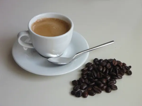 Xícara de café saboroso fresco com grãos de café — Fotografia de Stock