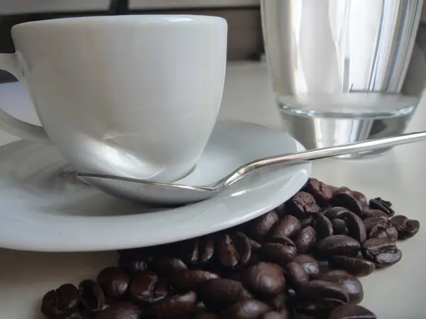 Чашка свіжої смачної кави з кавовими зернами — стокове фото