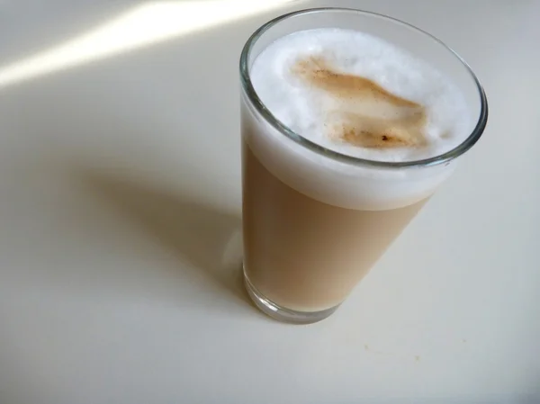 Caffe latte en un vaso en un tablee blanco — Foto de Stock