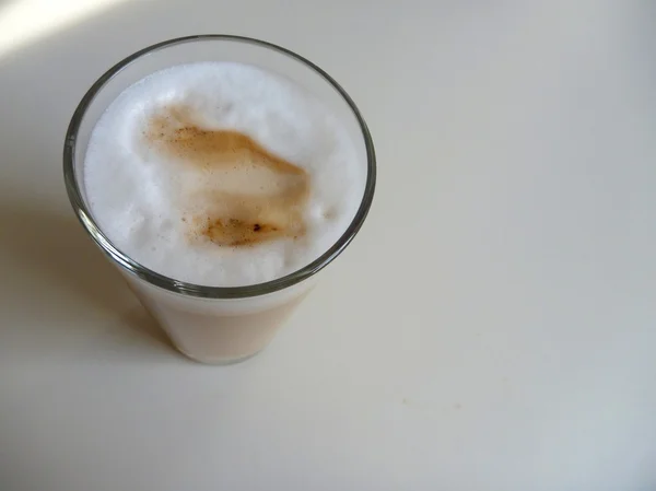 Café latte em um copo em uma mesa branca — Fotografia de Stock