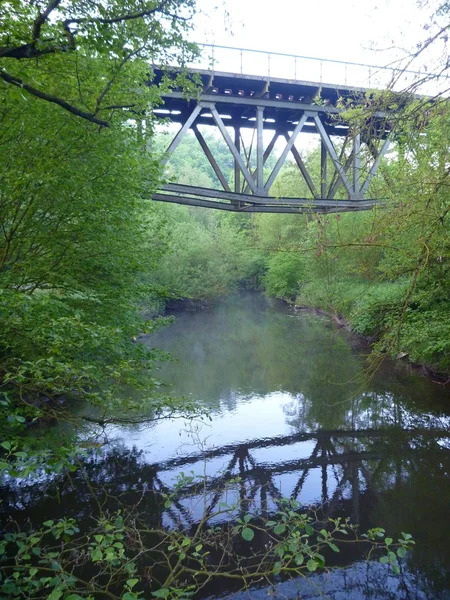 Reflecion of an iron arch bridge in a river — Stock Photo, Image