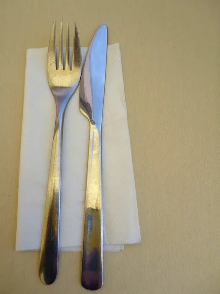 Нож и вилка с салфеткой на столе — стоковое фото
