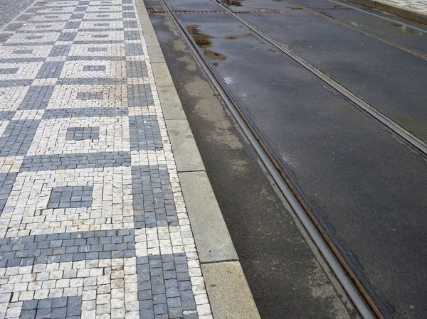 Straßenbahnlinie mit schwarzem und weißem Kopfsteinpflaster — Stockfoto