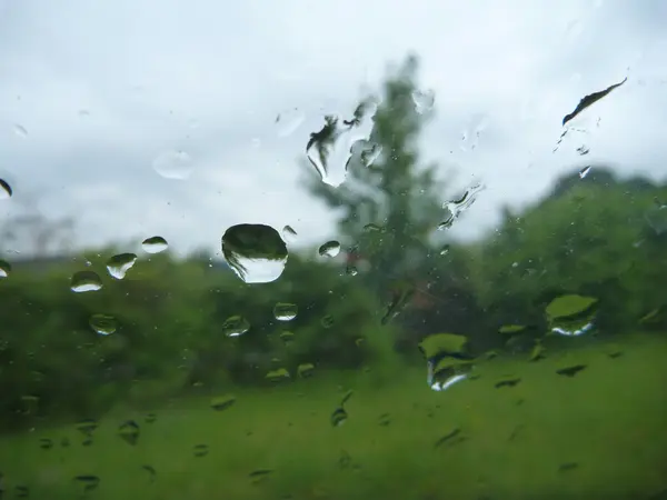 Krople deszczu na oknie zielony ogród — Zdjęcie stockowe