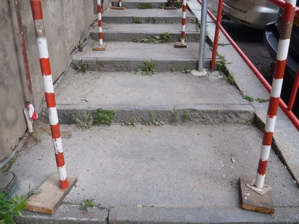 Andaimes vermelho e branco em uma rua inclinada — Fotografia de Stock