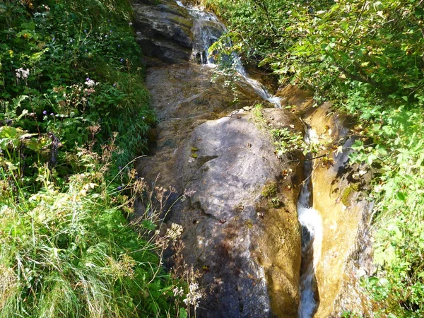 Ruisseau alpin tombant dans la roche — Photo