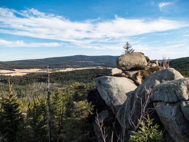 Sonbahar ormanı ve azgın granit kayalar.