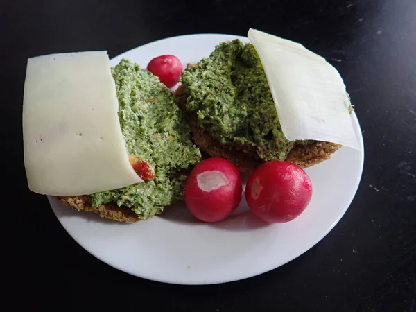 パンとペストのサンドイッチにチーズを添え大根を盛り付けました — ストック写真