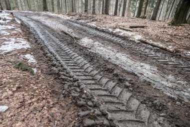 Çamurlu yol traktör tekerlekleri tarafından tahrip edildi.