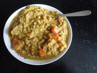 Bir kase sebzeli Hint mercimek çorbası.