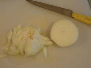 Mutfakta beyaz bir tahtada soğan doğruyorum.
