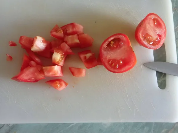 キッチンの白い板に赤いトマトを切って — ストック写真