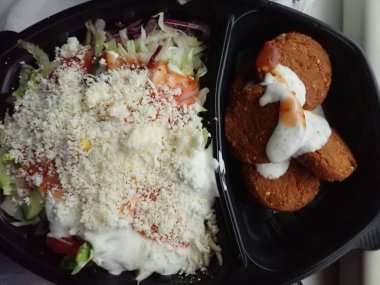 Sebze salatalı kızarmış falafel paket plastik tabakta.