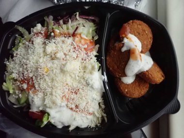 Sebze salatalı kızarmış falafel paket plastik tabakta.